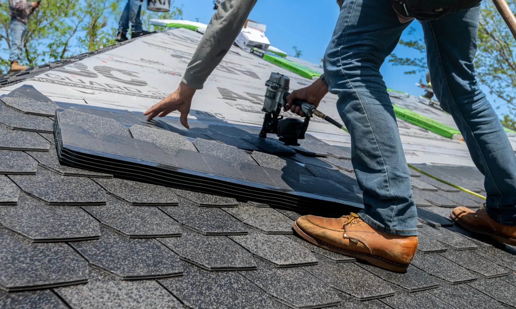 Roofer nailing a replacement shingle during a roof repair